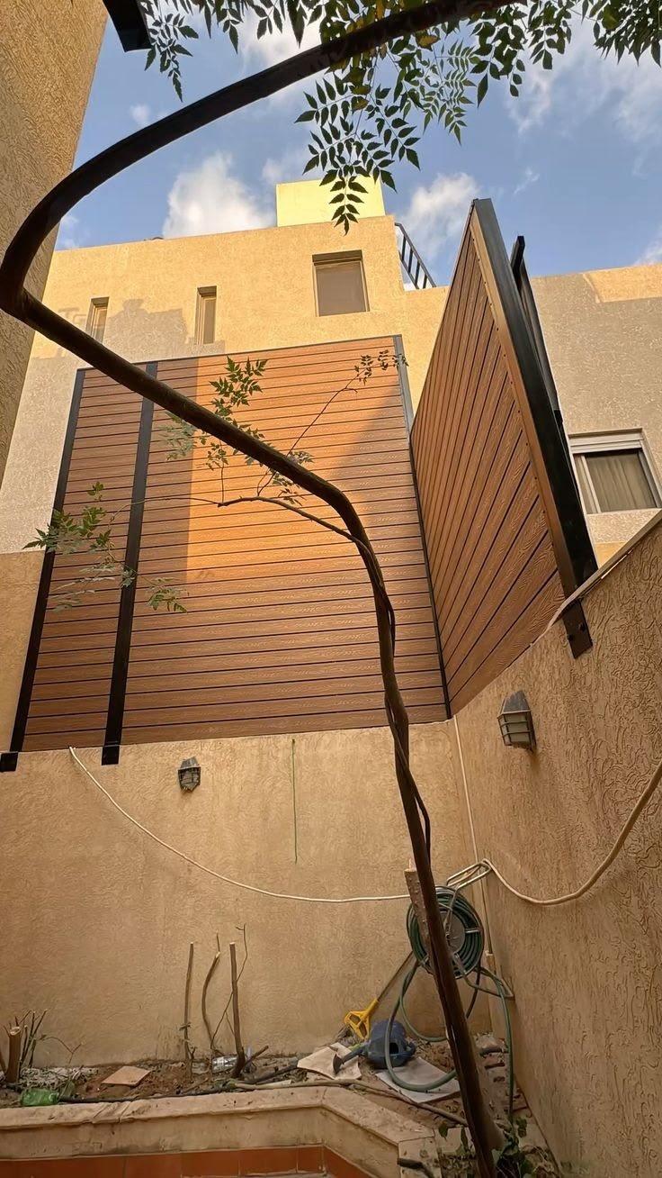 سواتر خشب WPC بني دافئ على جدار خارجي في حي العقيق المدينة المنورة